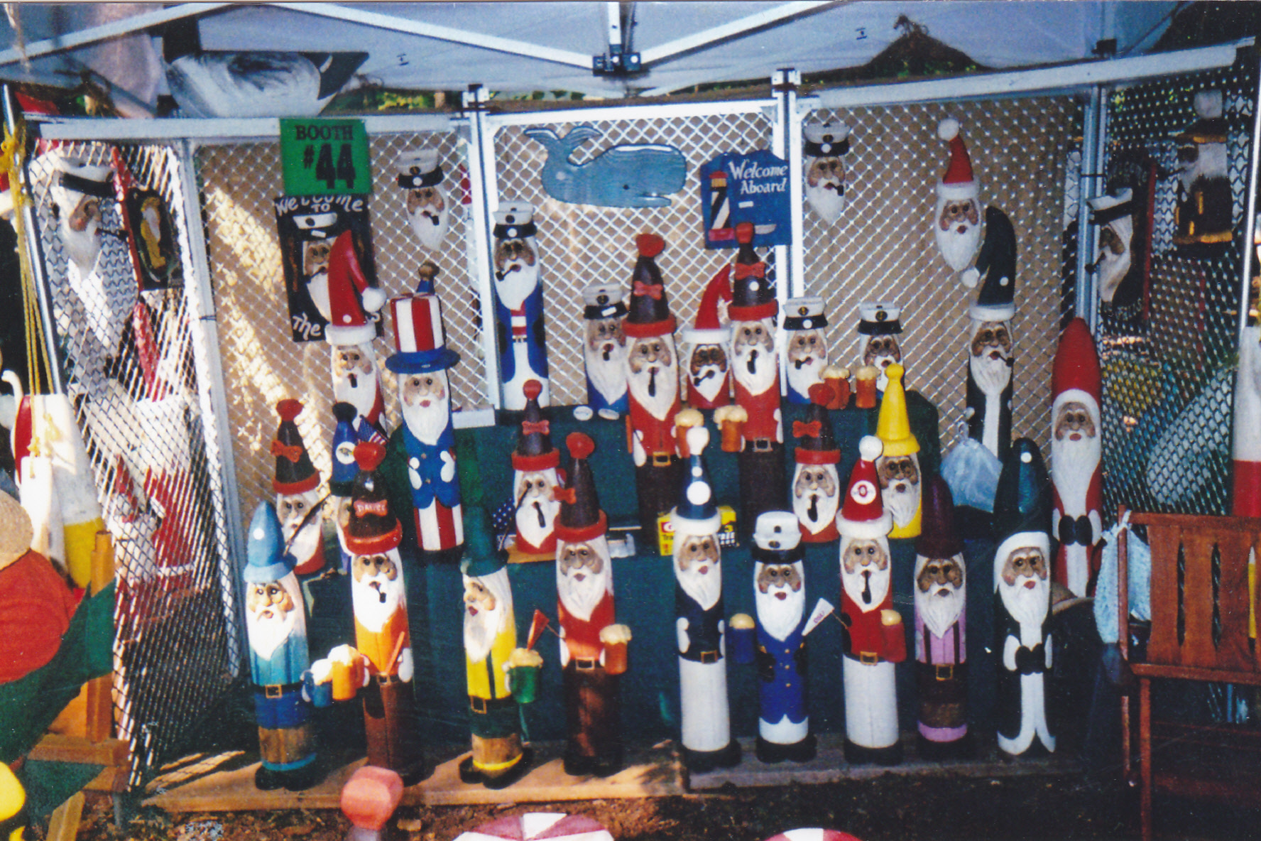 Santa Claus sculptures made out of wood wearing different holiday and ethnic clothing